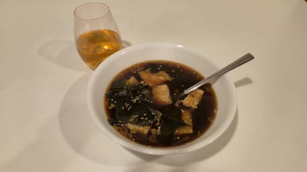 Vegan agadashi tofu with crispy tofu in kombu soy broth, garnished with scallions, a savory Japanese-inspired dish.