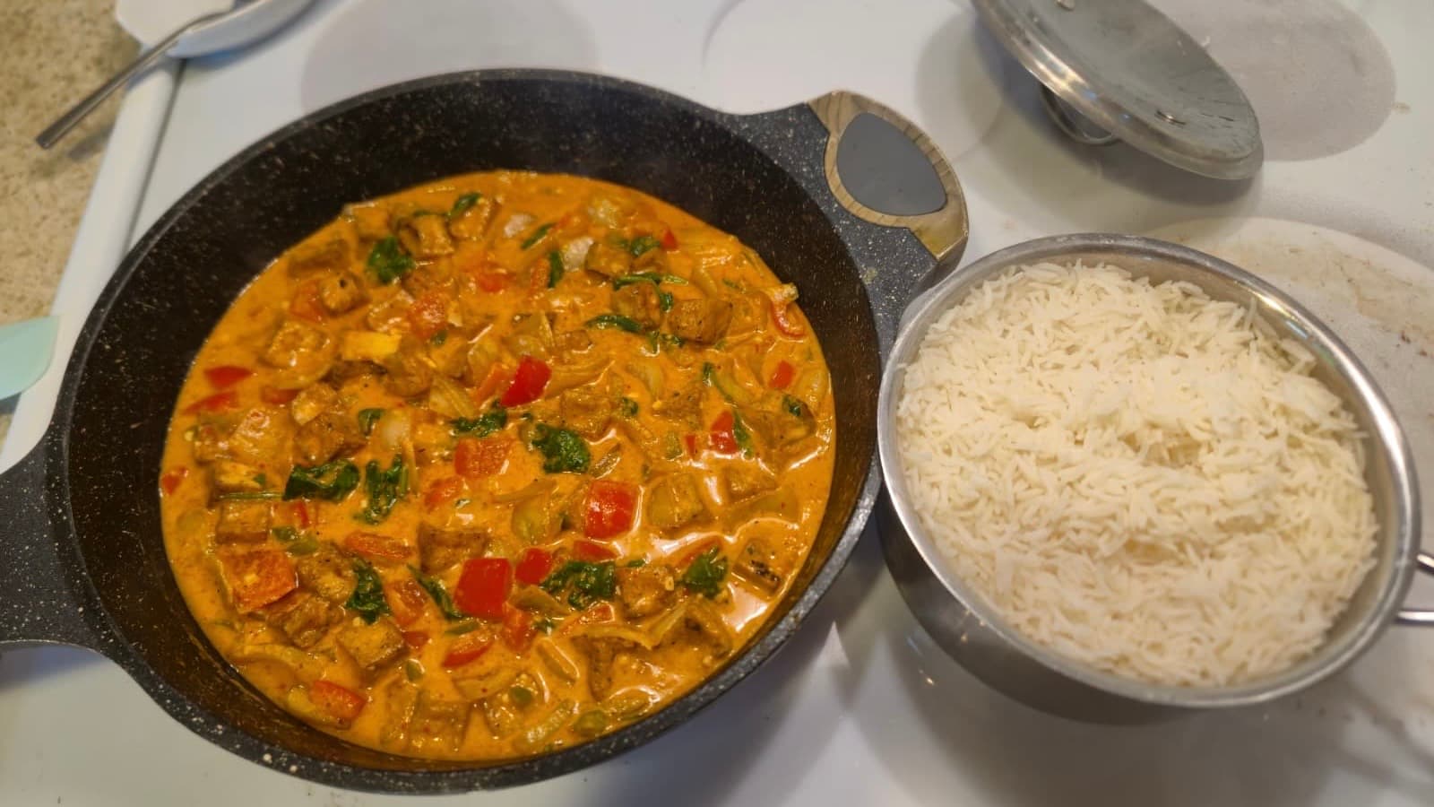 Vegan Thai red curry with tofu, bell pepper, spinach, and coconut milk, served over rice for a quick, flavorful meal.