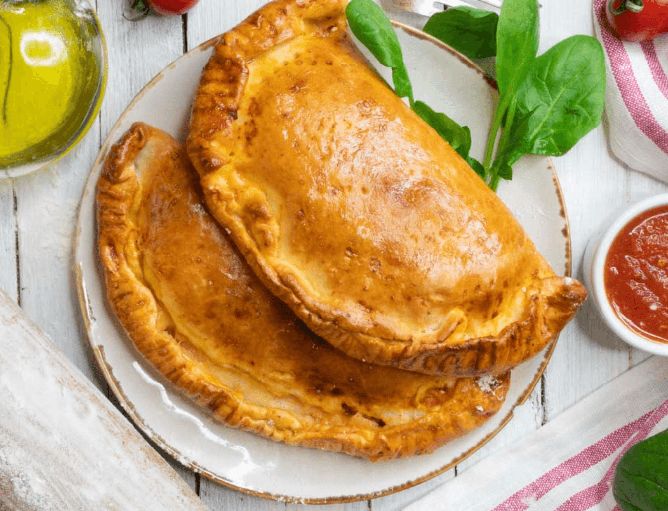 Vegan calzone filled with vegan sausage, spinach, vegan mozzarella, tomato paste, and seasonings, baked in an air fryer to a golden crust.